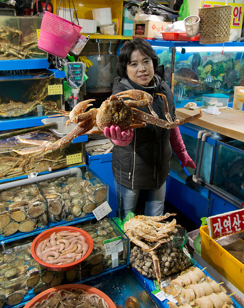 Fish market stall holder with crab
